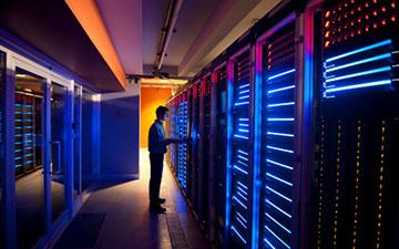 A man standing in a glowing server room